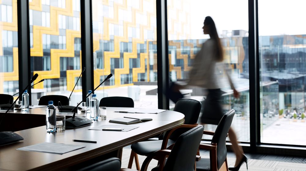 An executive boardroom set for a meeting, with a city view