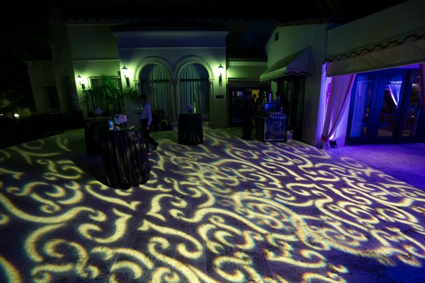 Dance floor washed in a gold scroll lighting pattern